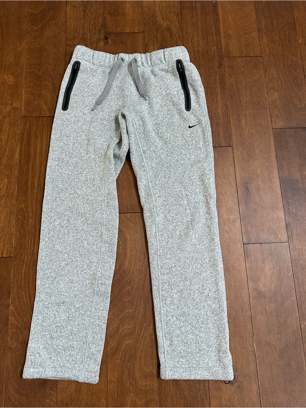 Nike Light Gray Women’s Fleece Joggers with Black Zipper Accents.